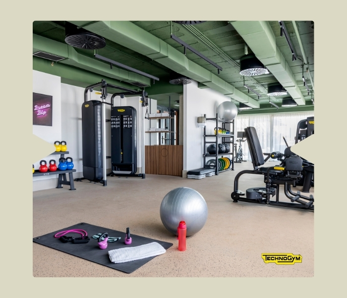Gimnasio completamente equipado en Calido Living, con vistas al exterior y maquinaria profesional.