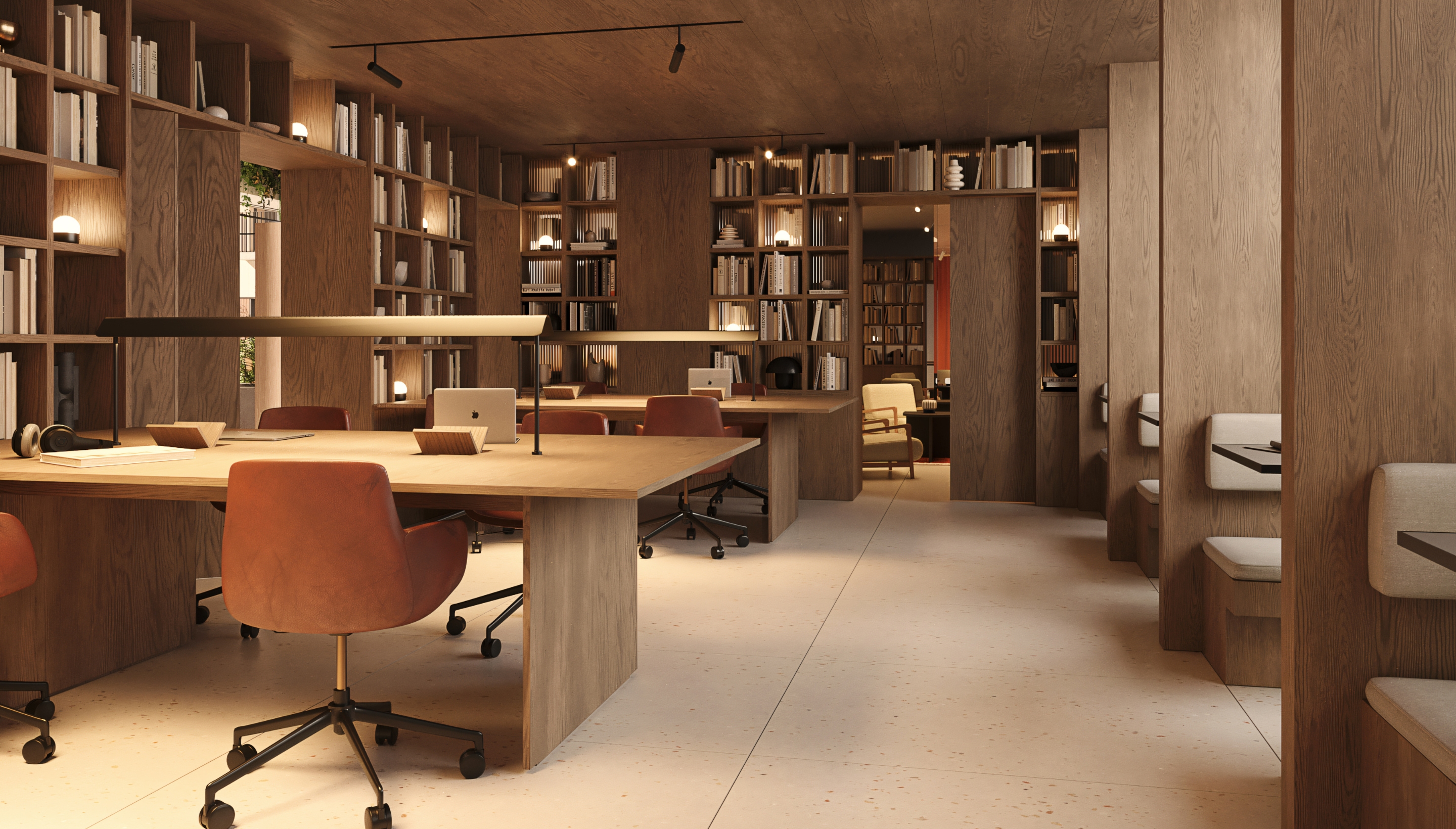 Sala de coworking elegante y moderna con mesas compartidas y estanterías llenas de libros en Calido Living Alcobendas.