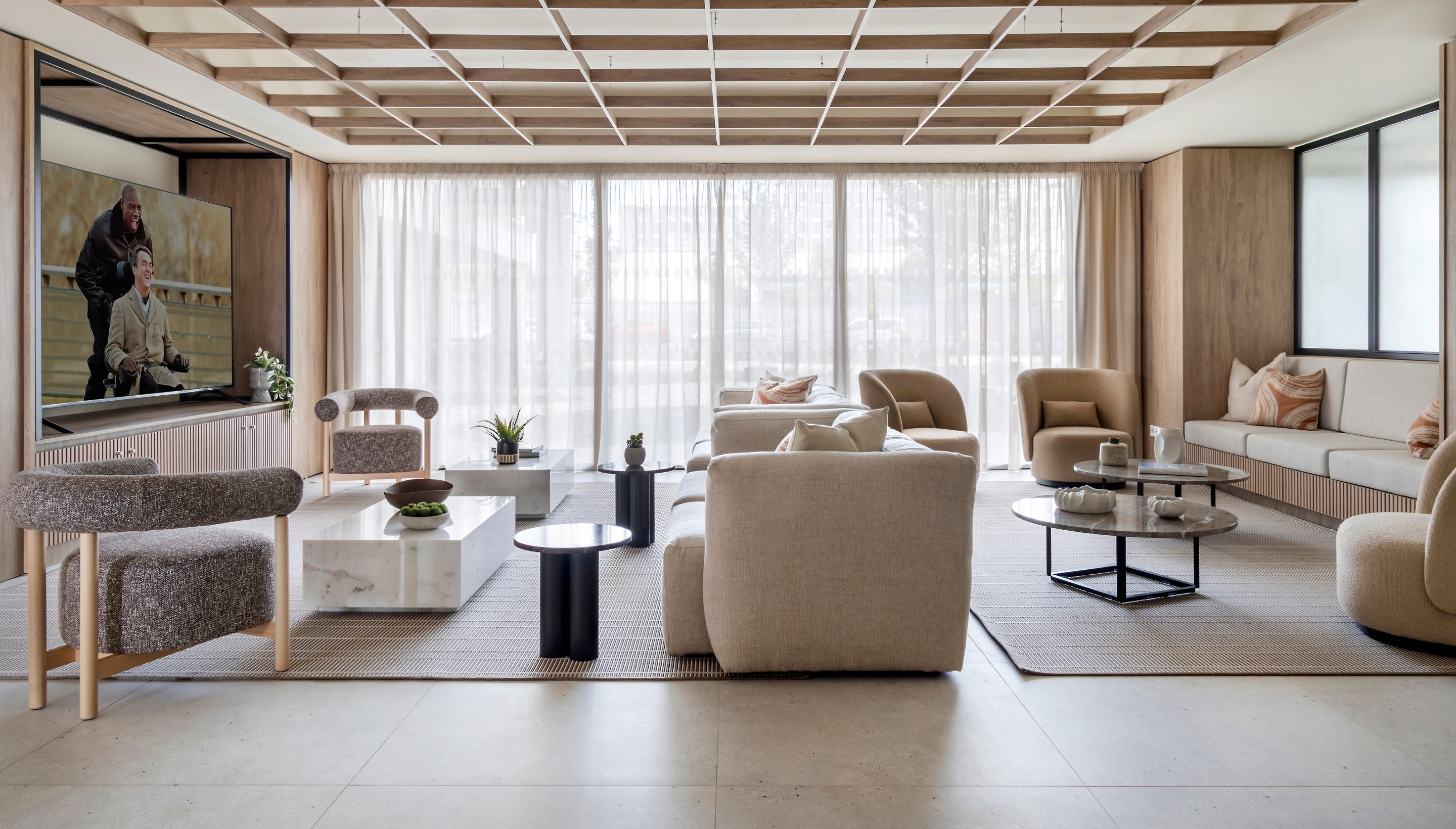 Área de proyección y entretenimiento con asientos cómodos y pantalla grande en Calido Living.