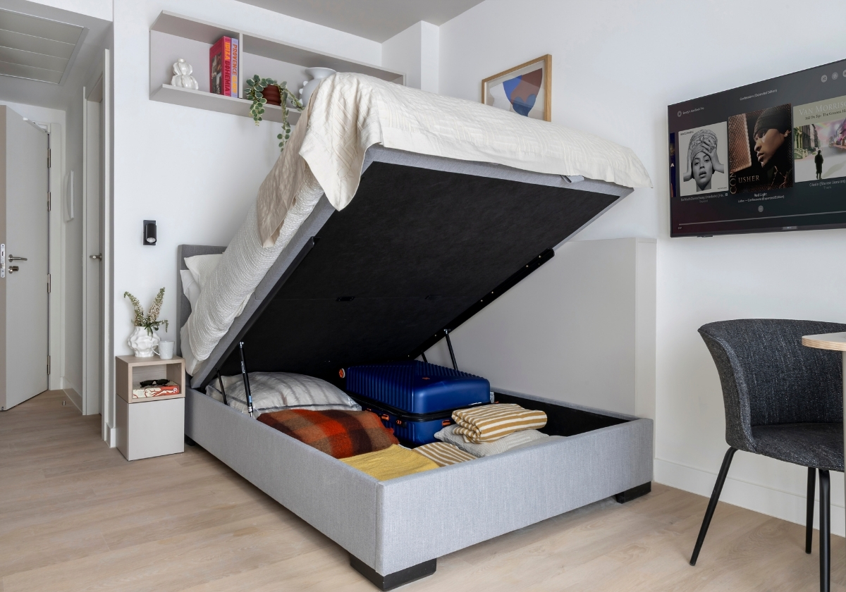 Cama con canapé abatible y espacio para maletas en estudio de Calido Valdebebas