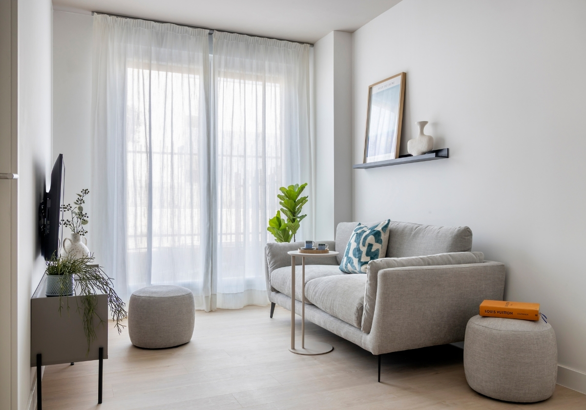 Salón amueblado con sofá y televisión en apartamento de Calido Valdebebas