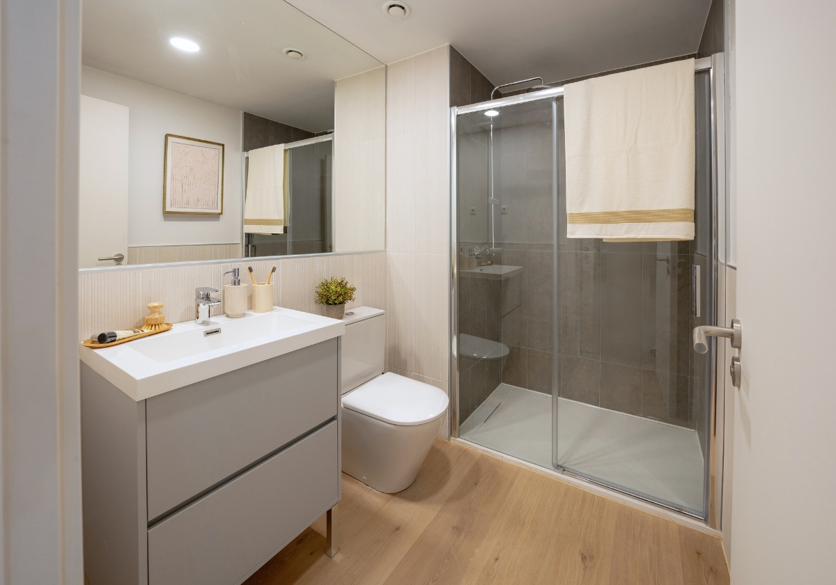Baño moderno con ducha de vidrio y decoración minimalista en Calido Living Alcobendas.