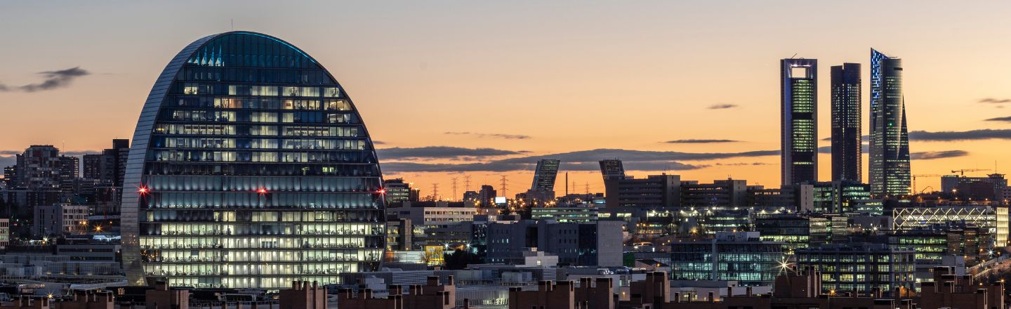 Vista panorámica de Madrid al atardecer, destacando el edificio Cepsa y las Cuatro Torres Business Area.